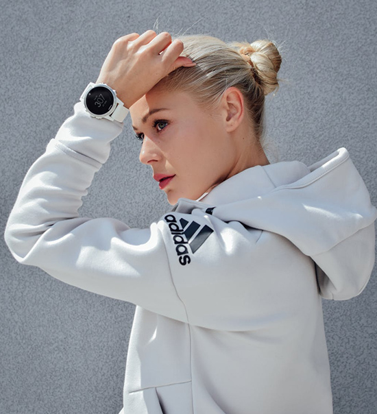 a woman in an addidas hoodie and white watch